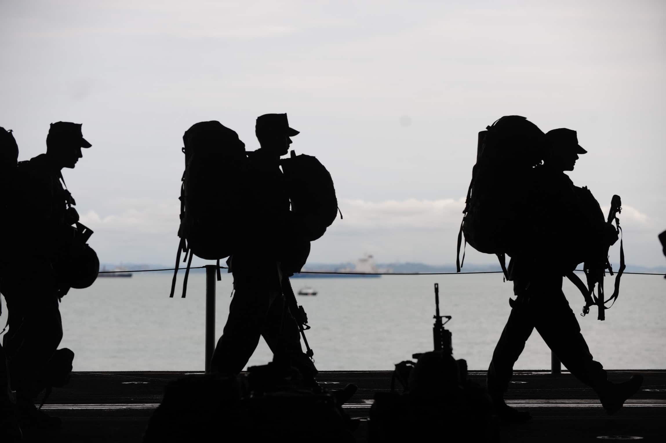 Silhouette of military soldiers walking.